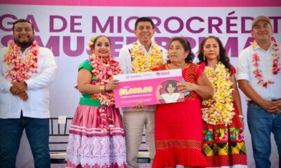 Salomón Jara, gobernador de Oaxaca, con collar de flores en entrega de créditos a mujeres