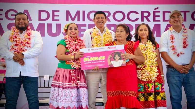 Salomón Jara, gobernador de Oaxaca, con collar de flores en entrega de créditos a mujeres