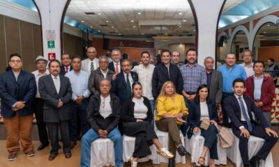 Encuentro del líder del PVEM con líderes sindicales, en un salón con arcos blancos