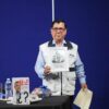 Edmundo Cázares, periodista, sosteniendo una caricatura suya
