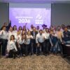 Miembros del partido Partido Nuevas Ideas con camisa blanca y fondo morado