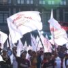 Personas vestidas de guinda con banderas de Morena