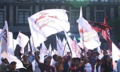 Personas vestidas de guinda con banderas de Morena