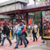 Maestros caminan en Tlalpan, hay una publicidad rayada