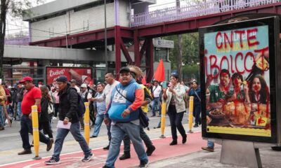Maestros caminan en Tlalpan, hay una publicidad rayada