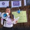 Integrante de colectivo con megáfono en manifestación